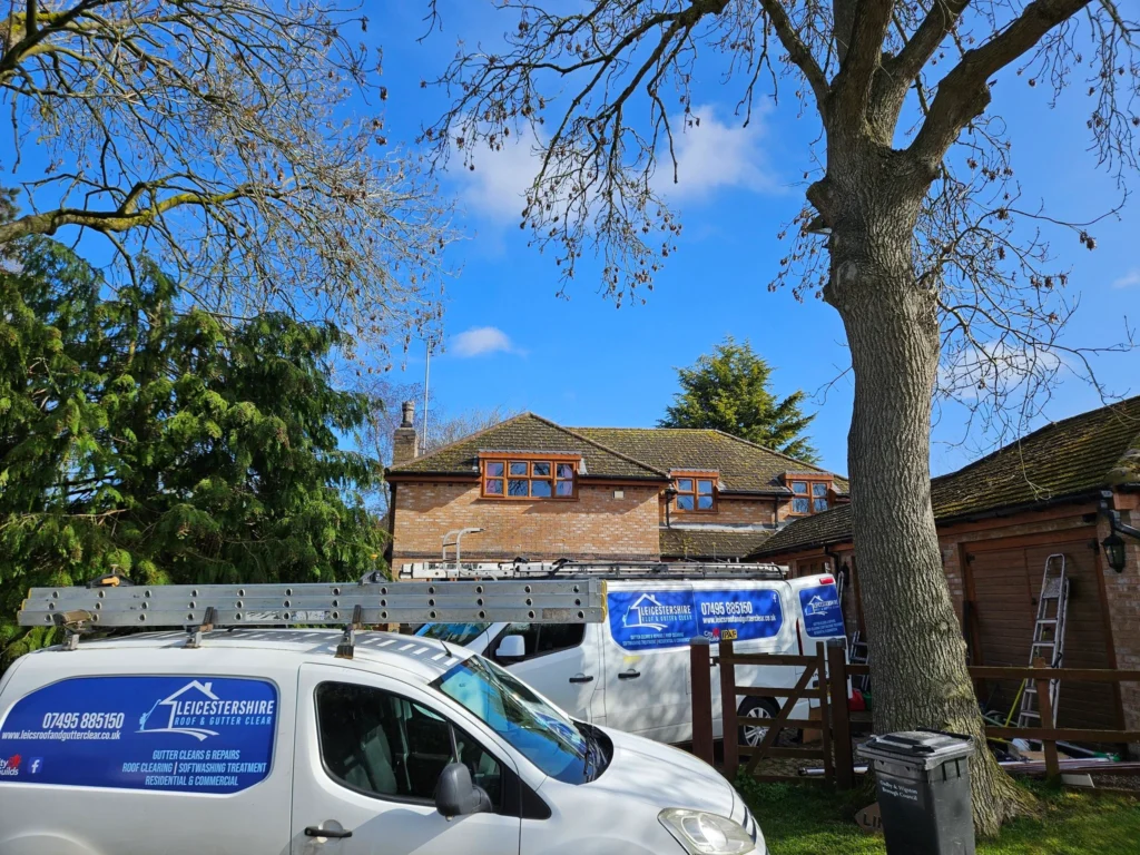 Professional roof cleaner Leicester with branded vans carrying out roof maintenance and cleaning
